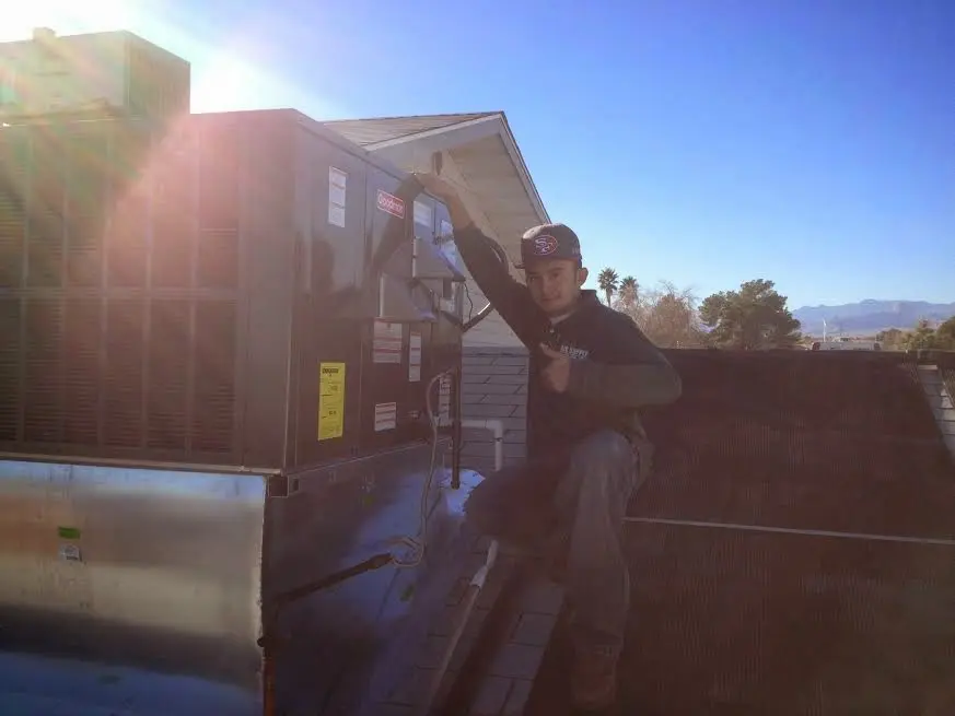HVAC technician performing HVAC Inspection on a rooftop unit in Oceola